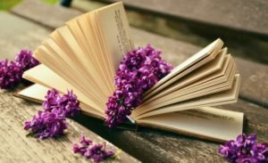 Creativity, a book draped with purple flowers