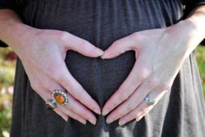 soul story: hands making a heart with an amber ring