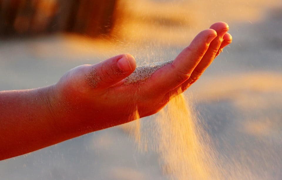 a hand with sunlit sand...